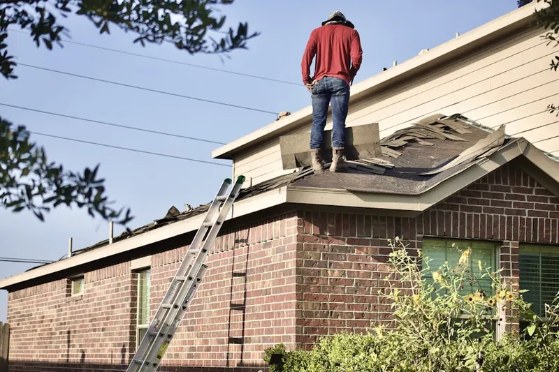 Professional roofer working on a residential roof in Downey Road